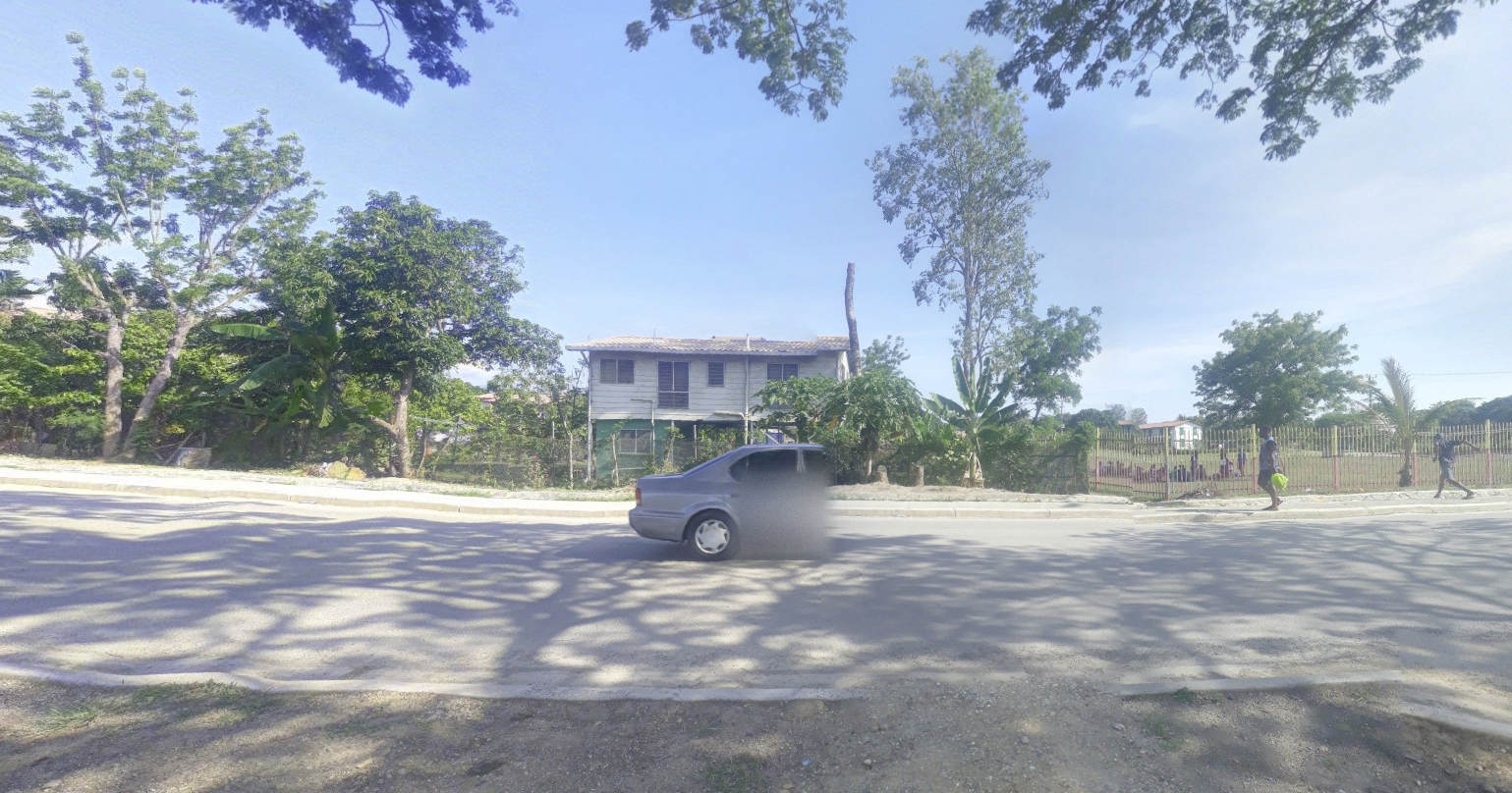 picture of a street. a car is in the middle, although, the front part of it is missing from the photo. it just fades out halfway through